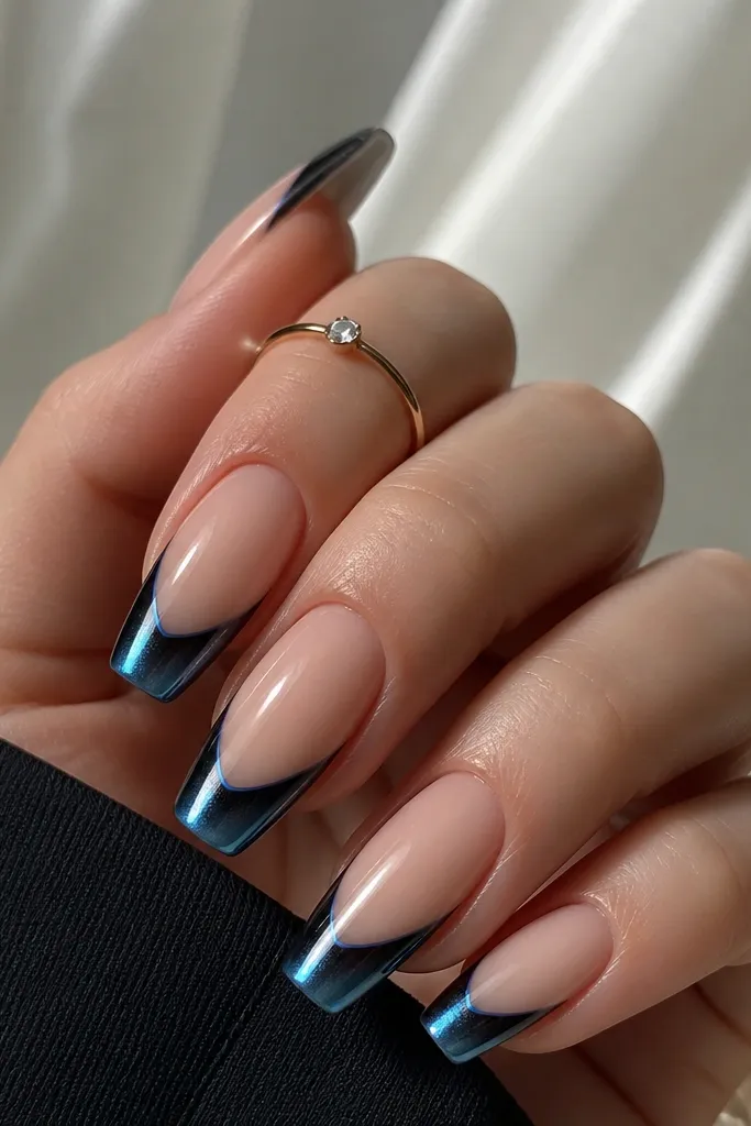 Coffin nails with nude base and black cat eye French tips. Along the very edge of the French tip, there's a thin aurora blue reflection line (holographic-like), while the center cat-eye stripe stays white-blue bright.