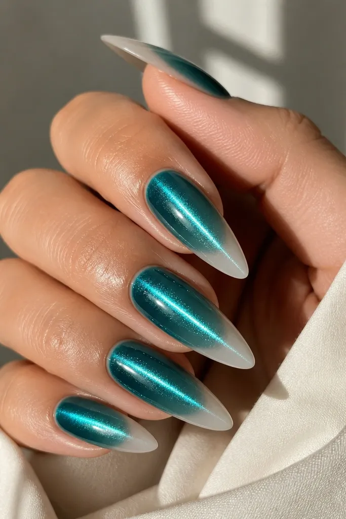 Teal cat-eye nails with a centered shimmer line that looks like a glowing stripe. The French tips are milky nude, semi-opaque, and blend softly into the teal base.