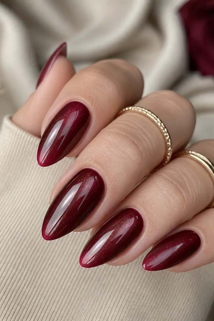 Burgundy cat-eye nails with a centered shimmer stripe. The French tips fade from darker burgundy near the border to lighter wine at the tip edge, with a smooth gradient.