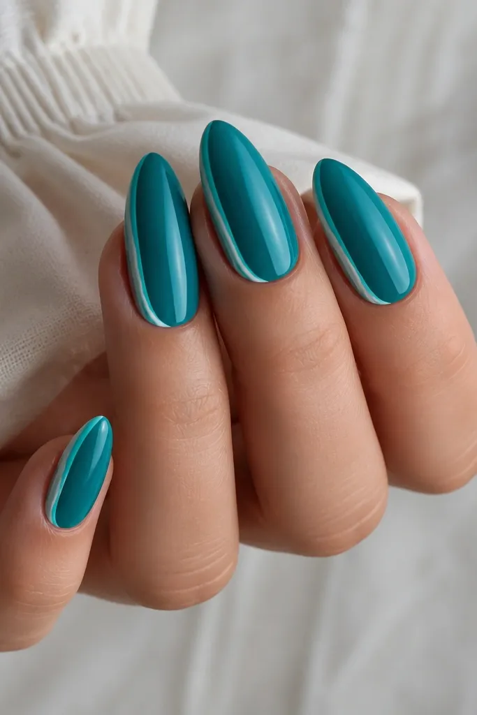 Ocean teal cat-eye nails with a bright aqua stripe. Instead of a full french tip, there are thin white lines running down both side edges near the tip area.