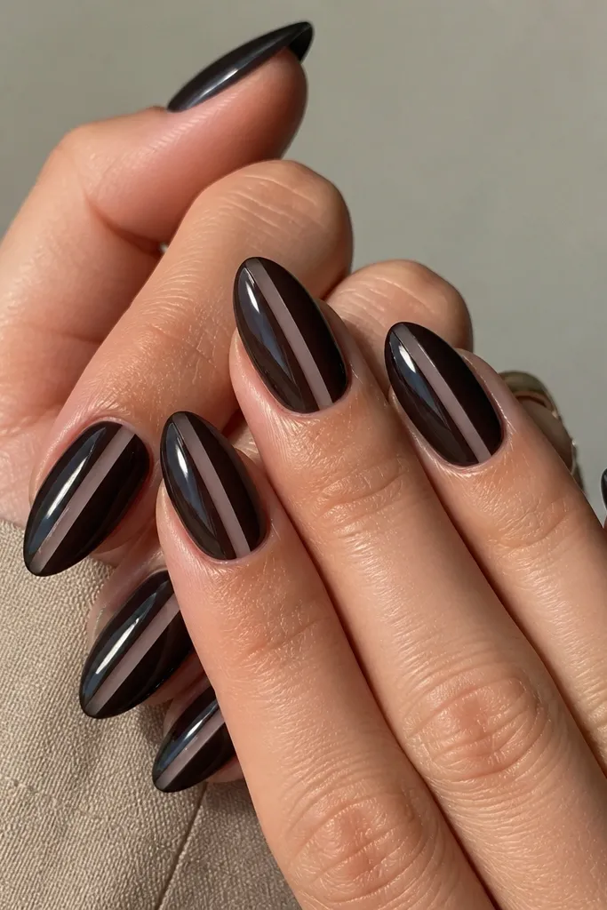 Almond nails with a sheer-to-opaque black jelly look that still shows a slightly glassy depth. In the middle of each nail there is a narrow vertical clear stripe from cuticle to tip, leaving a clean negative-space line. The rest of the nail is glossy and smooth with light reflections.