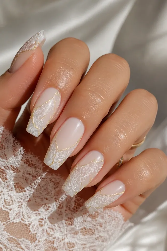 Medium coffin nails with a sheer white base and delicate lace-like linework in white. Thin gold lines run like thread along the lace edges, mostly on the sides and near the tip. The overall look is glossy and detailed but airy.