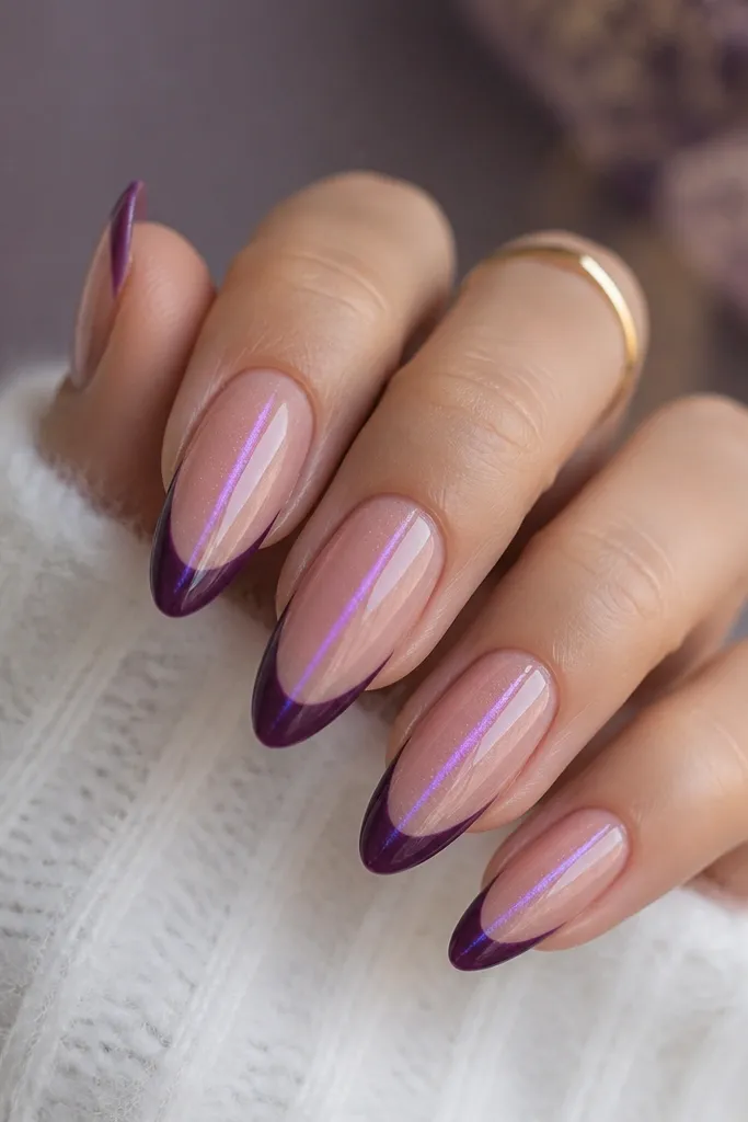 Almond nails with a violet cat eye stripe centered on a nude base. French tips are deep purple instead of white, with a sharp smile curve. Everything is glossy and reflective.