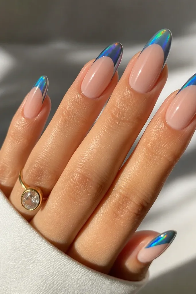 Long oval nails with a nude base. French tips are blue cat eye with a bright streak, then an aurora shimmer overlay gives a rainbow sheen that shifts across the tip. The smile line is crisp and the top coat is glossy.