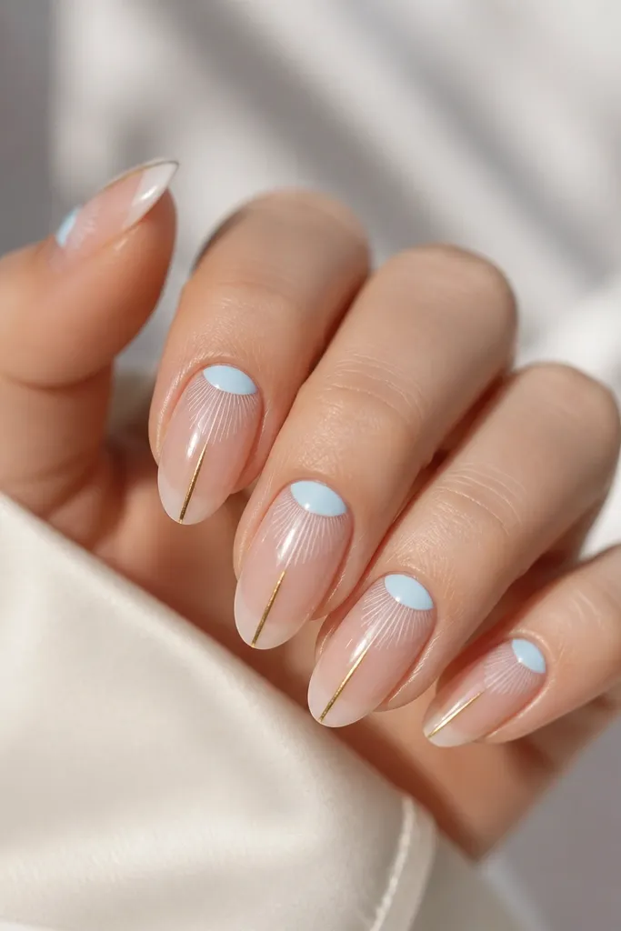 Medium almond nails with a baby blue half-moon at the cuticle. Across the center are thin white reflective strokes that taper toward the tip, and a narrow gold line runs from mid-nail to the tip.