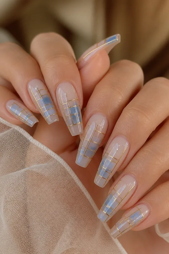 Medium coffin nails with a stained-glass look: blue translucent squares separated by thin gold outlines. Inside some squares are tiny white dot lights, and the background is sheer milky nude.