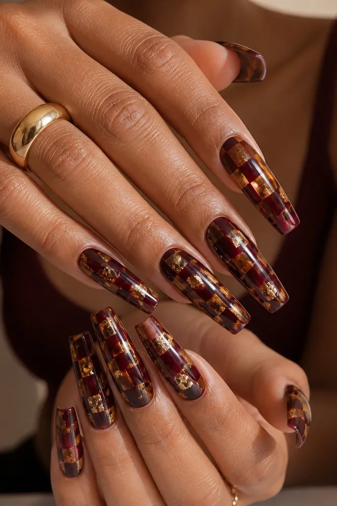 Long coffin nails with a checker-like tortoise pattern: burgundy blocks alternate with caramel brown and gold flecks; glossy shine.