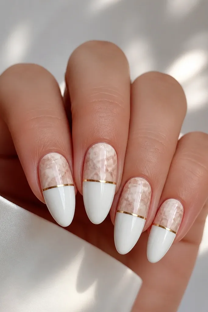 Five almond nails. The bottom half is solid white, the top half has soft marble swirls. At the boundary between halves is a thin gold line running horizontally like a belt. Glossy finish.