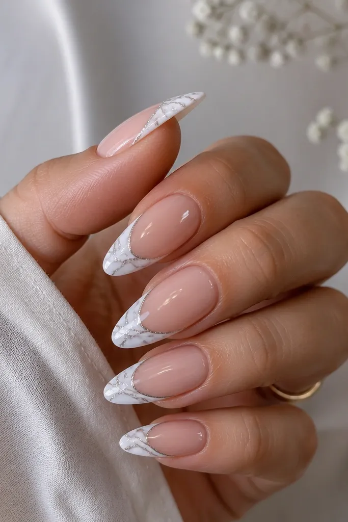 Long almond nails with white french tips. Inside the tip area, thin marbled veining is drawn in soft gray, with a cat eye vein in silver running through it. Nude base, glossy top coat.