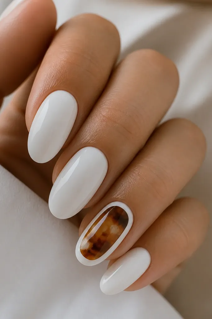 Four nails are solid milky white. One accent nail has tortoise shell inside a thin white border, with warm browns and small white breaks. Nails are glossy and the accent looks like a framed mini artwork.