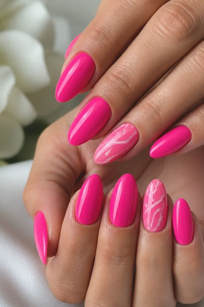 Hot pink almond nails with white marble swirls on two accent nails. The white lines look like thin veining, with glossy reflections and clean edges.