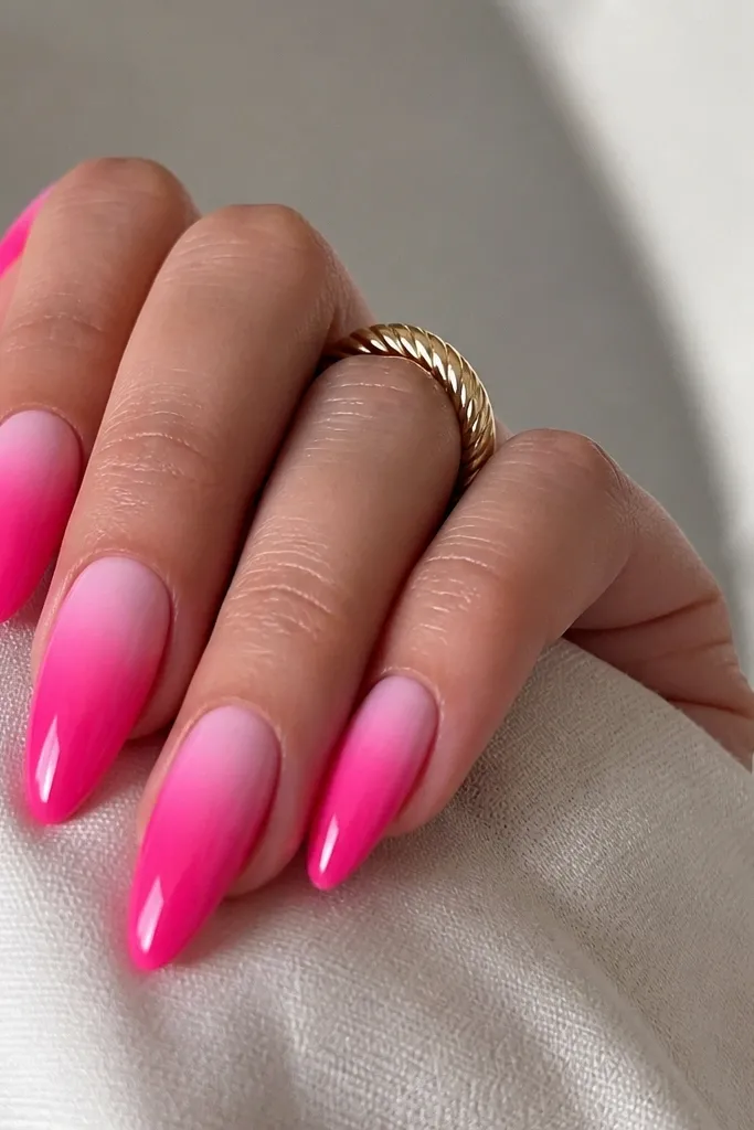 Hot pink almond nails with a soft white aura ring around the cuticle area. The aura fades outward and blends into the hot pink with a glossy, airy look.