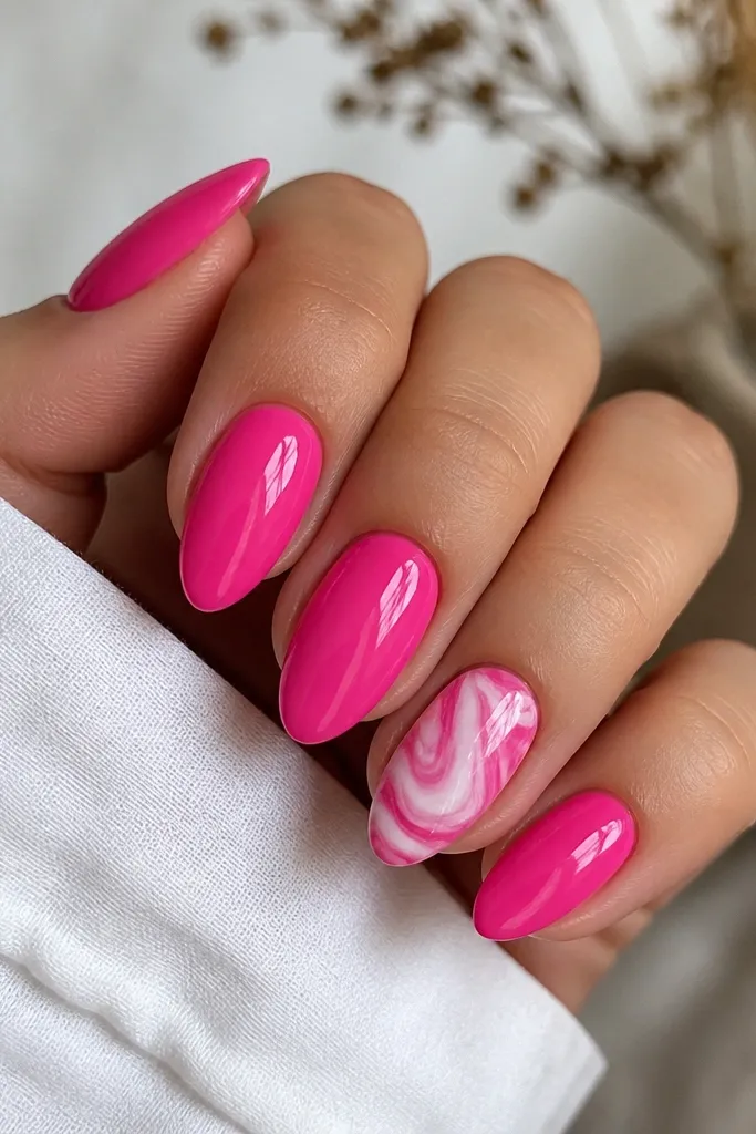 Bright hot pink nails with a glossy finish. One accent nail has white marble swirls that curl like waves across the center, with thin grey shadow lines. The marble looks fluid, not painted thickly.
