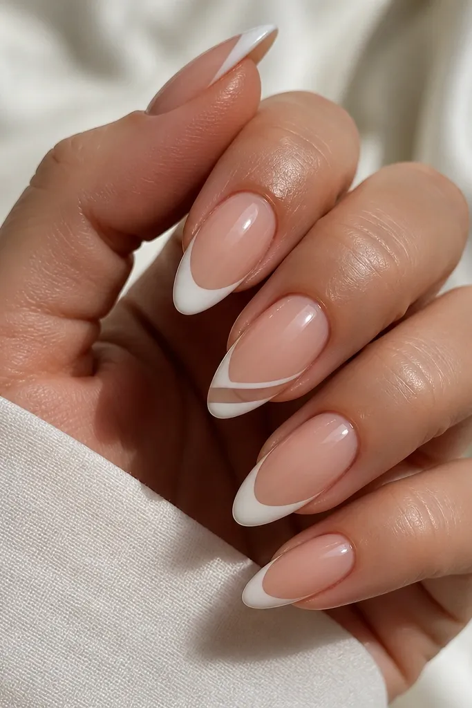 Almond nails with a sheer nude BIAB base and white French tips. On two nails, there's a diagonal negative-space window through the French, leaving a small clear strip that runs from smile line toward the side. Glossy finish.