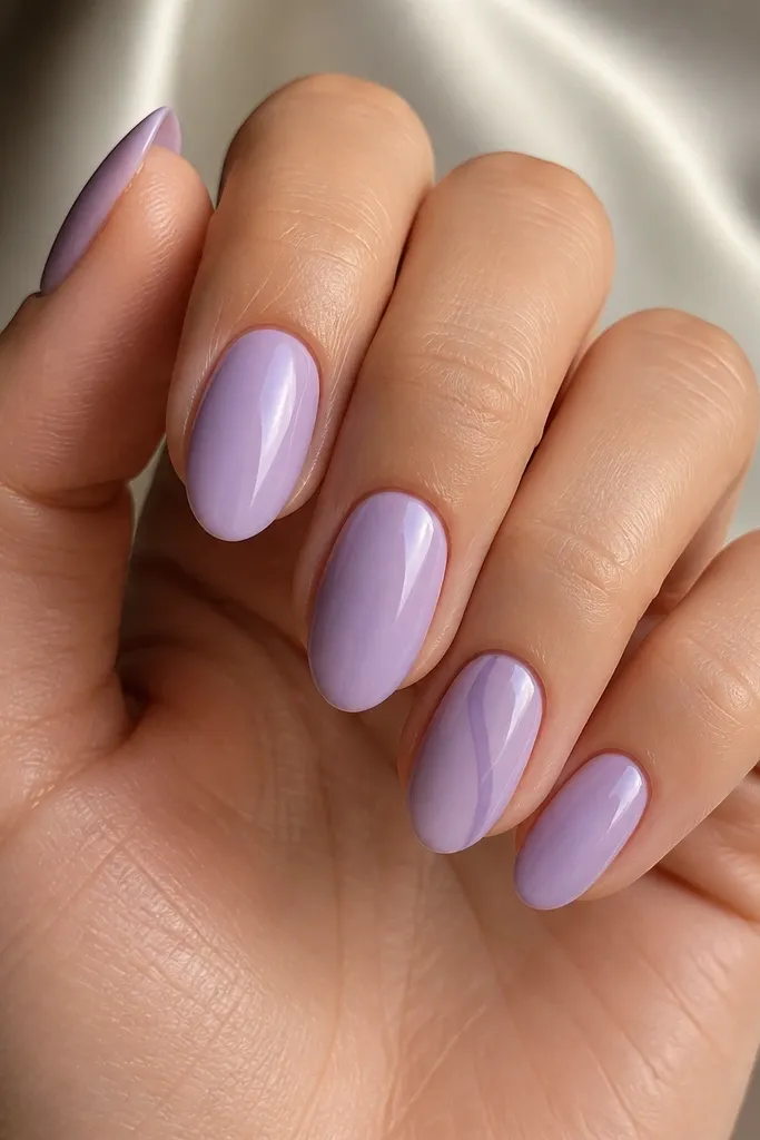 Soft lavender BIAB nails, glossy. The ring finger has a wispy accent line in a slightly darker lavender that curves gently from near the cuticle toward the center. Other nails are plain lavender.