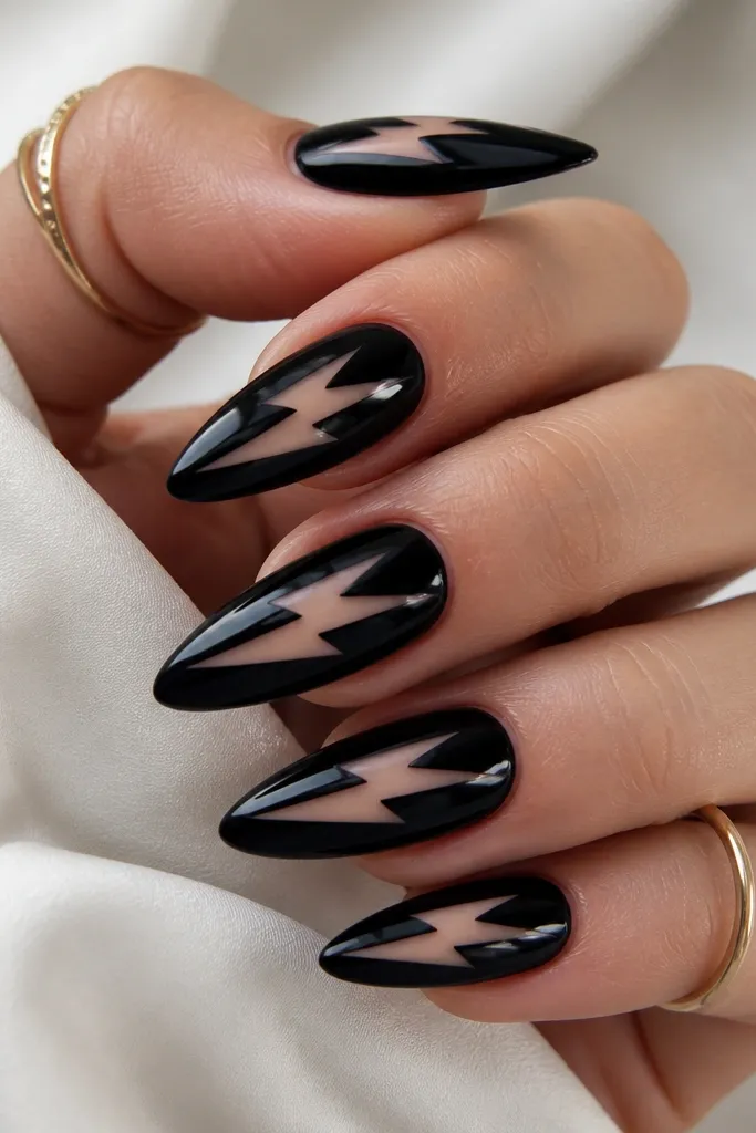 Long almond nails with a glossy black base. A sharp lightning bolt shape is cut out in negative space near the center, showing nude beneath. The edges of the bolt are crisp and glossy.