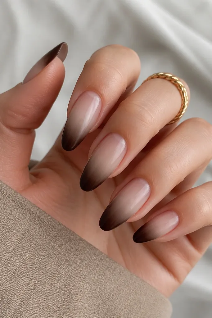 A frosted nude gradient that starts sheer at the cuticle and turns milky toward mid-nail. The tips are solid chocolate brown, with a soft blend line that fades into the nude. The finish is glossy but slightly diffused from the frosted gradient.