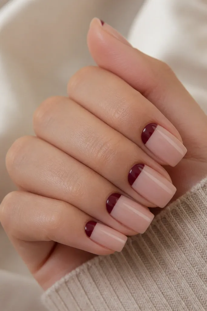 Square nails with nude base. Each nail has a deep plum half-moon near the cuticle, leaving the center clear and the rest of the nail nude, with a glossy finish.