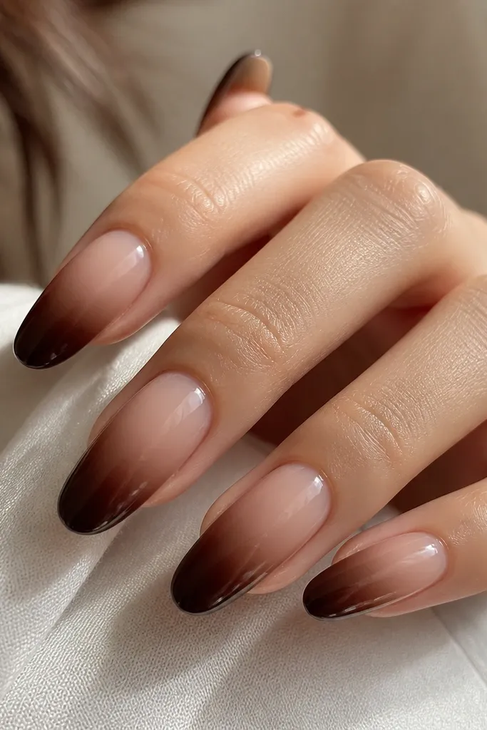 Nails with sheer nude base that fades into dark chocolate brown at the tips. The gradient is smooth and soft, with no harsh line. Glossy finish.