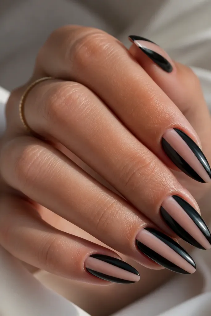 Almond nails with a clear nude base. Two black side panels frame a clear center stripe, creating a sleek negative-space look. Everything is glossy and clean at the cuticles.