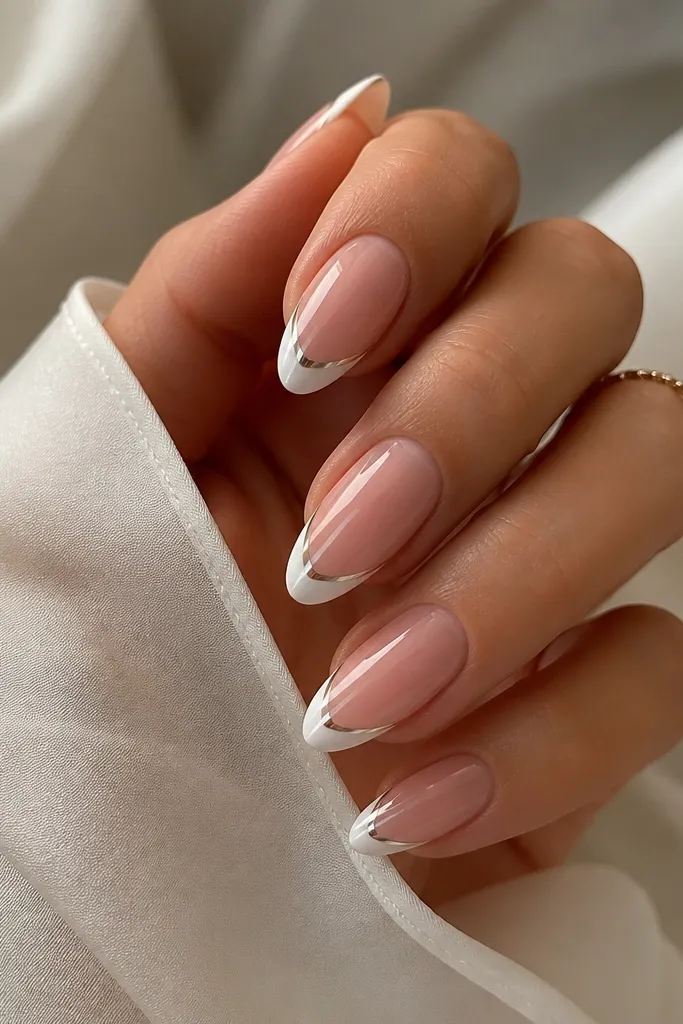 Almond nails with a rose-pink base and a thin white French tip. A narrow silver chrome line runs down the center of the French tip, reflecting like foil under light.