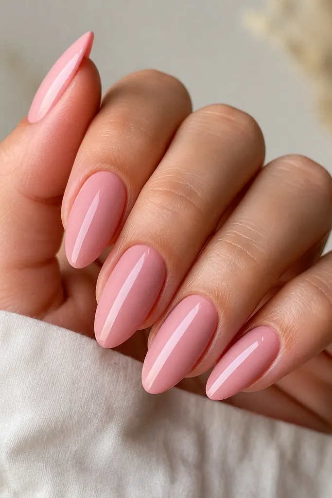 Pink almond nails with a soft matte finish overall. Down the center is a glossy stripe in slightly lighter pink, making a smooth reflective line from near the cuticle to the tip.