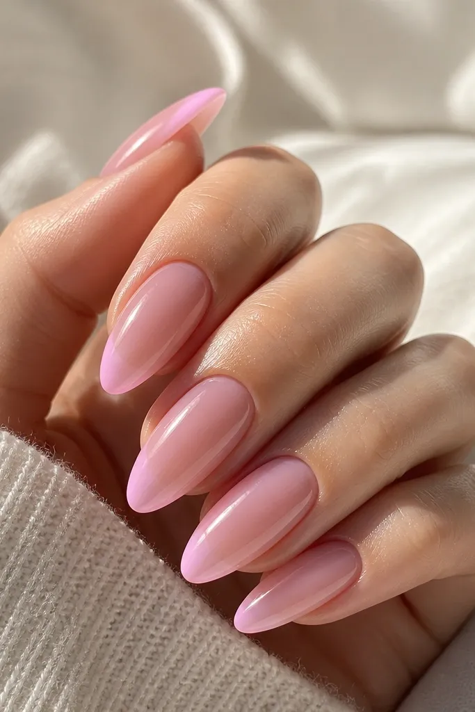 Pink almond acrylic nails with a soft rosy mauve base. The tips fade into a lighter mauve-pink rather than a sharp white French line. The transition is smooth and glossy, and the nail tips look slightly brighter at the very edge.