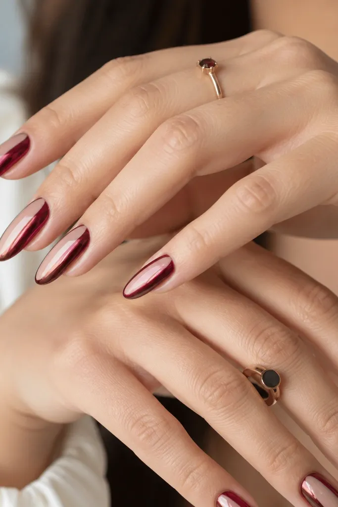 Almond nails where the sides are deep wine red chrome, but the center strip is clear or sheer, creating a vertical negative-space panel. The chrome is mirror-bright along both edges.