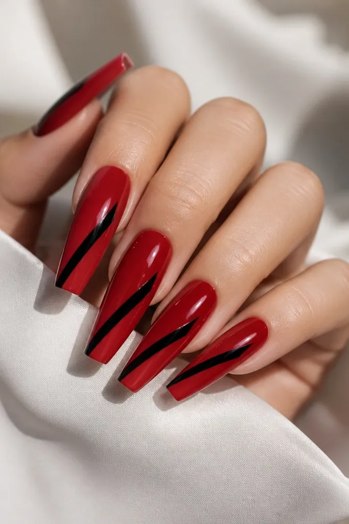 Long coffin nails with a glossy deep red base. A single diagonal black pinstripe runs from lower left to upper right on each nail, and the stripe has a crisp edge. The rest is clean, with clear reflection.