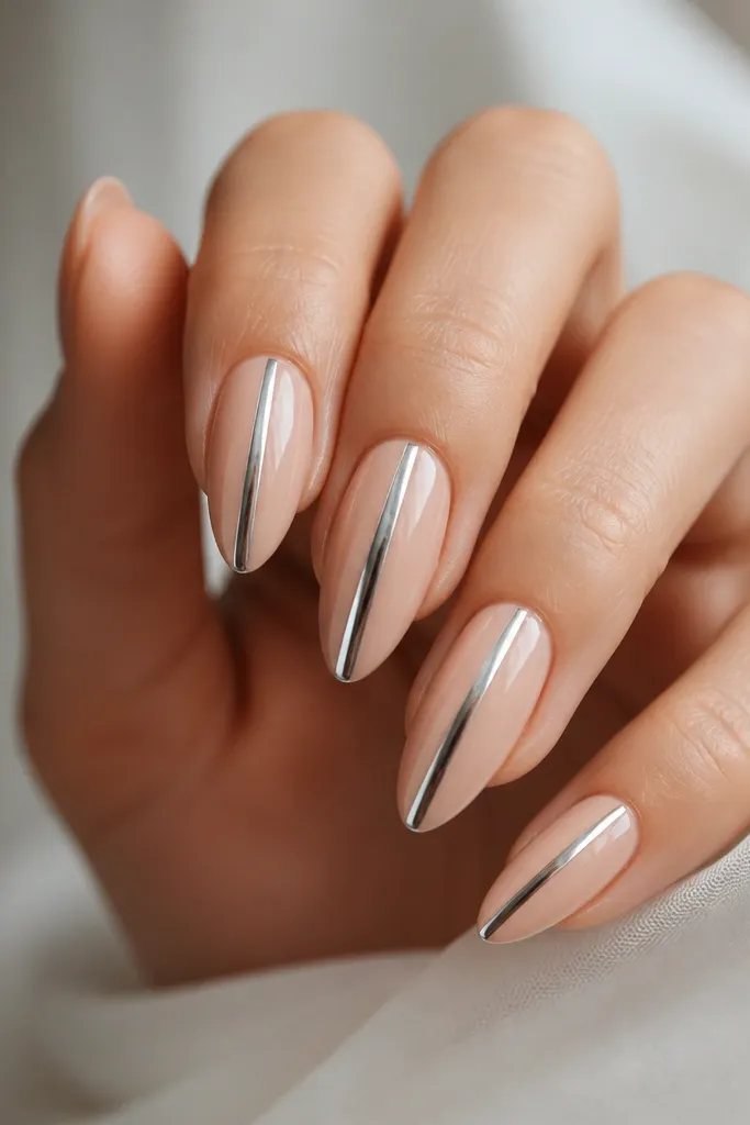 Nude almond extensions with a single vertical chrome stripe running down the center; the stripe is mirror-like silver with crisp edges; glossy top coat.