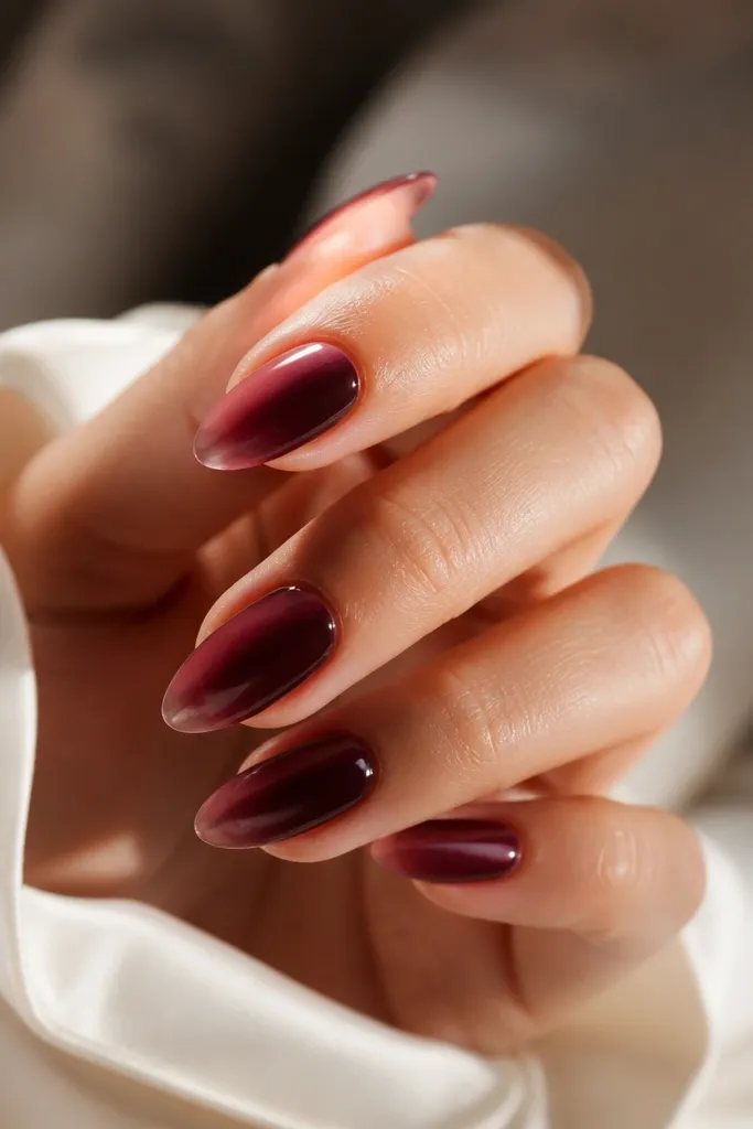 Almond nails with a soft French tip that fades from a lighter wine near the tip into a deeper wine at the base; glossy finish with a velvet-like smoothness.